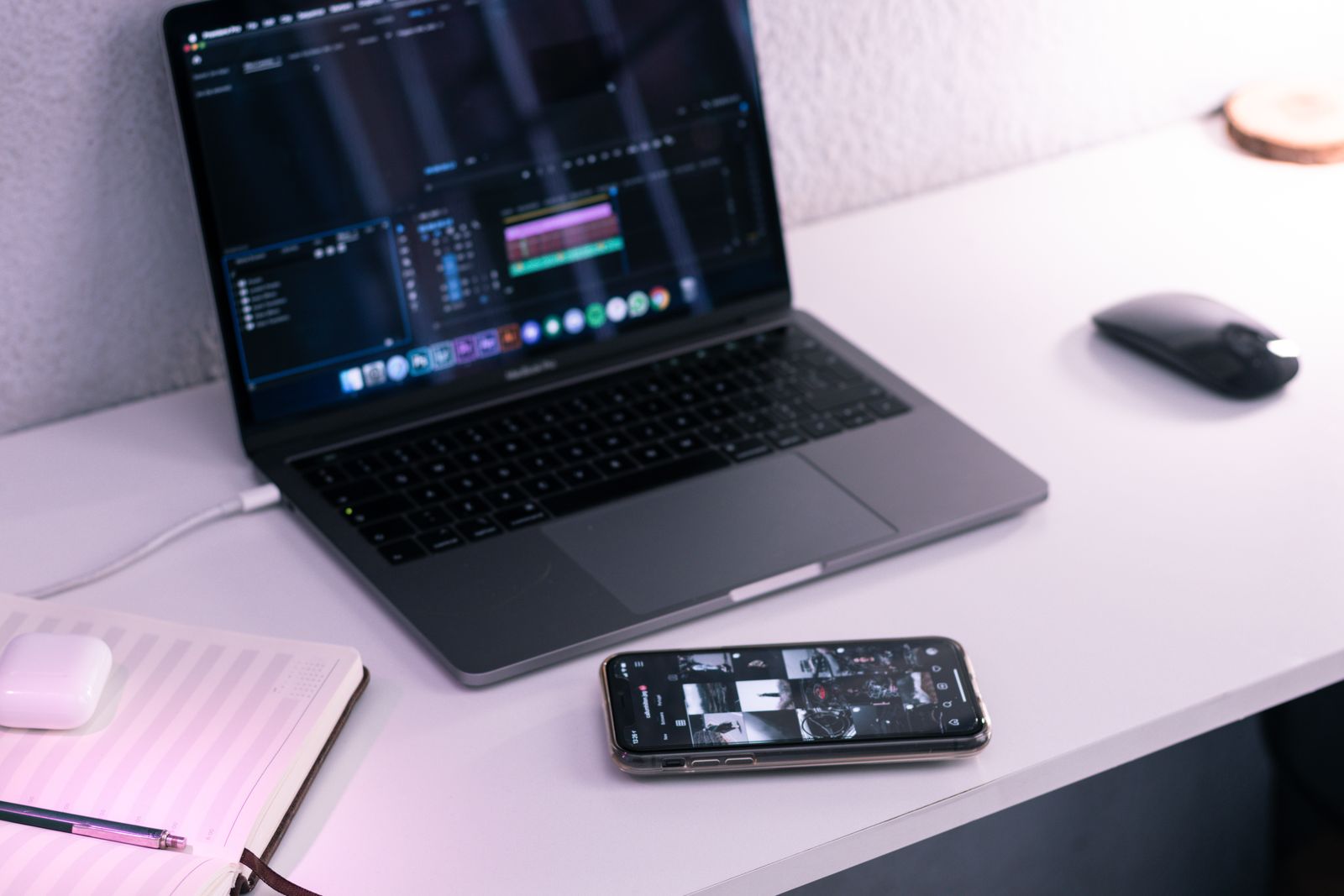 A laptop, phone, and notebook on a desk
