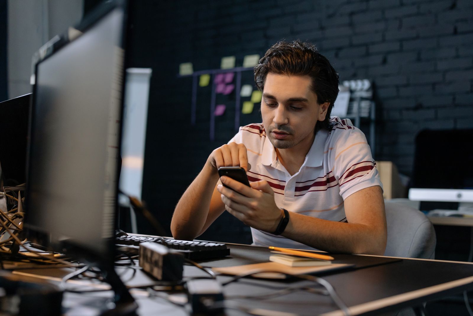 A man checking his phone at a desk