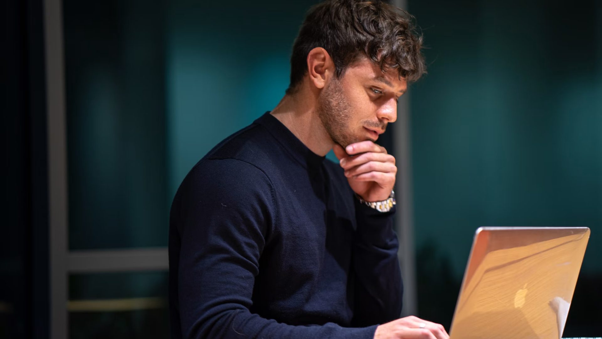 A man thinking at a laptop