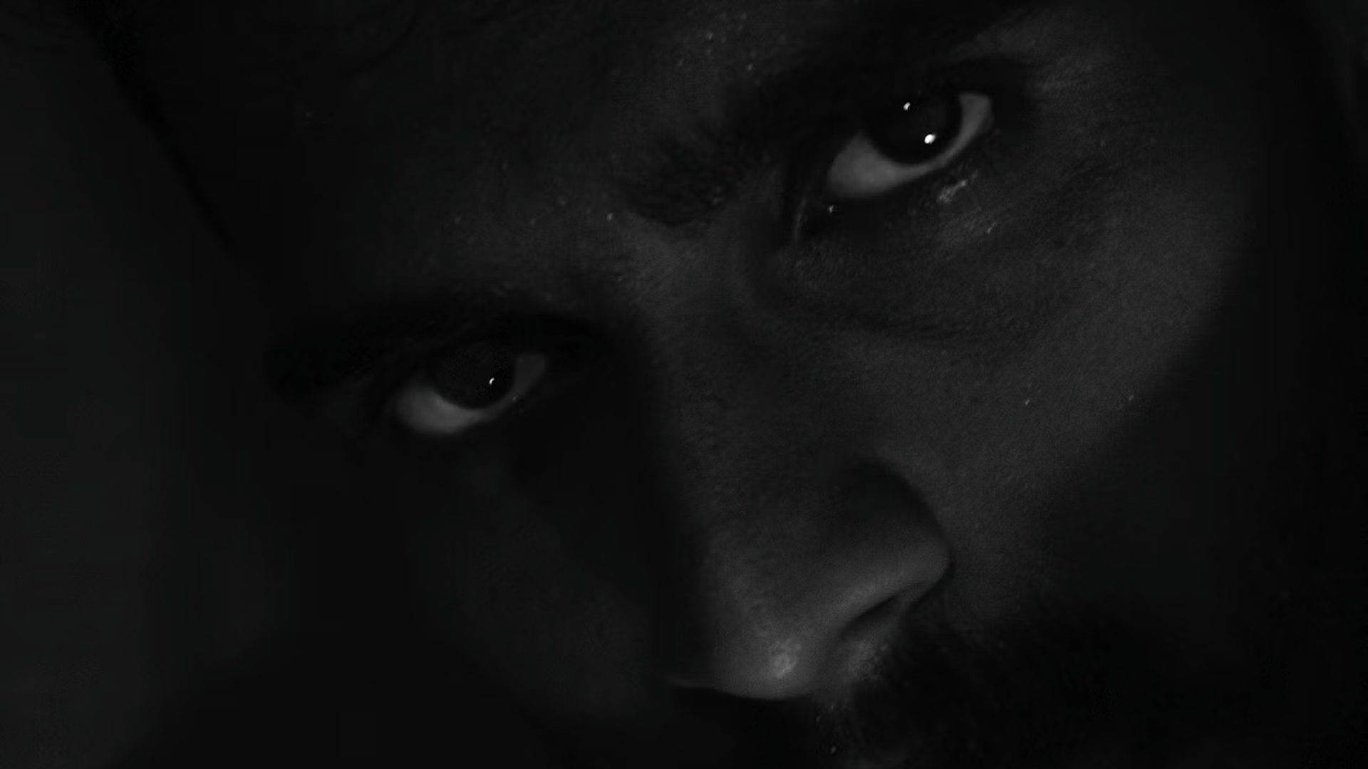 A close-up of a man's eyes in low light