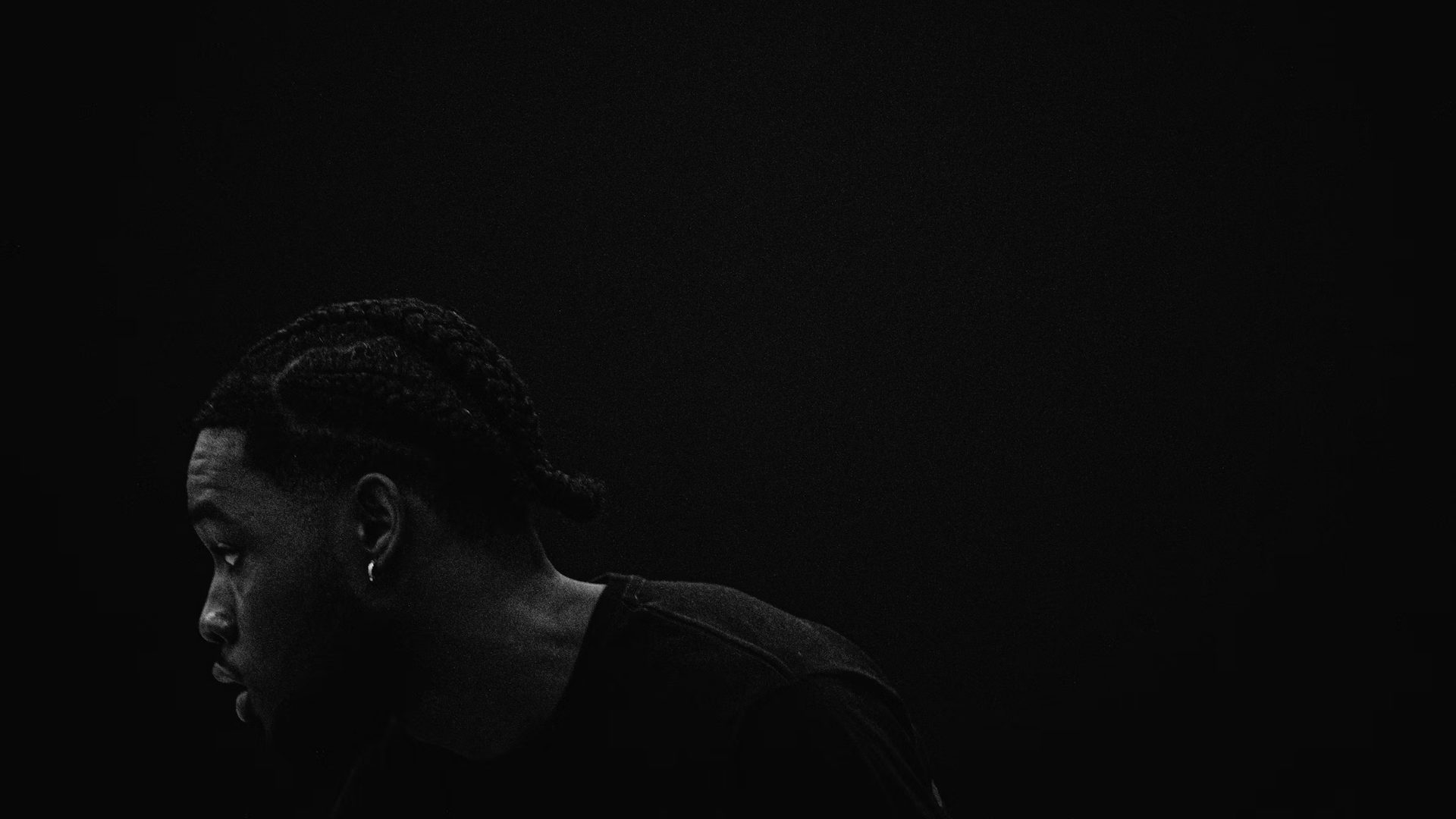 A young man sitting alone in a dark room